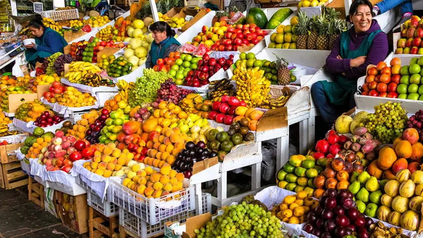 Backpackers exploring tropical fruits in a Peruvian market